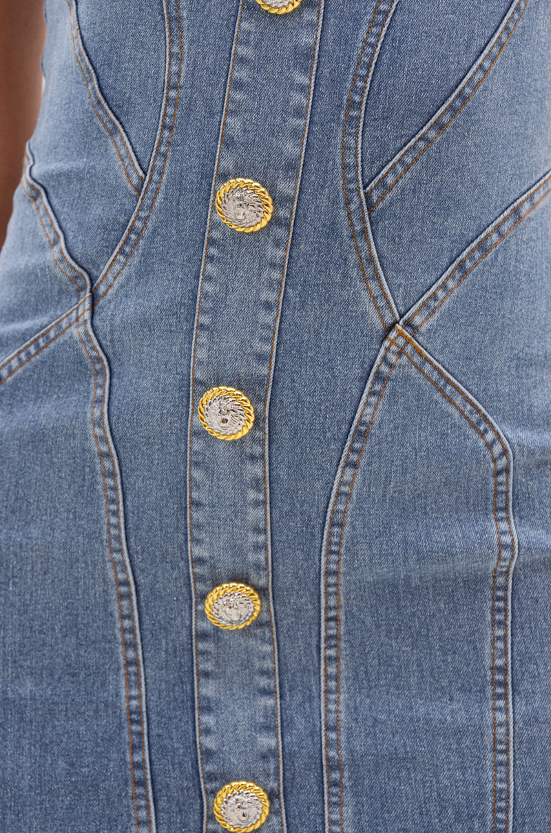 Close-up of the AMRATA DENIM MIDI DRESS WITH GOLD BUTTONS, a vintage-inspired blue denim dress with decorative gold buttons, standout brown stitching, and curved seams that highlight its body-contouring silhouette. 5