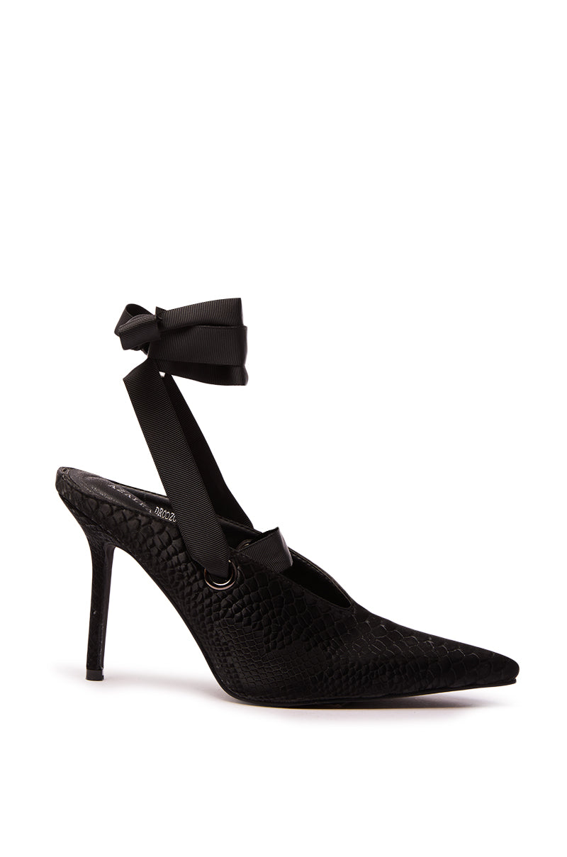 The AZALEA WANG DRODZOV BLACK LIQUID LUXE RIBBON TIE PUMP features a pointed toe, snakeskin print heel, slim stiletto silhouette, and a black ribbon ankle strap tied in a charming bow.