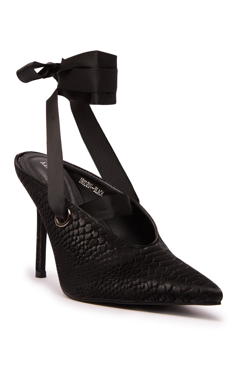 The AZALEA WANG DRODZOV BLACK LIQUID LUXE RIBBON TIE PUMP features a pointed toe, black textured faux leather stiletto finish, and wide ribbon ankle ties that elegantly wrap around the ankle.