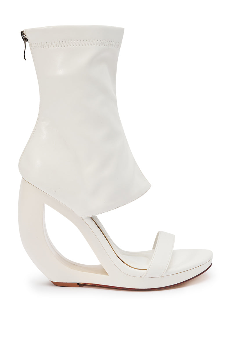 The AKIRA GOLD DUMISANI WHITE WEDGE OPEN TOE BOOTIE features a sculptural ankle-high wedge heel, soft white leather upper, and a stylish back zipper for comfort.