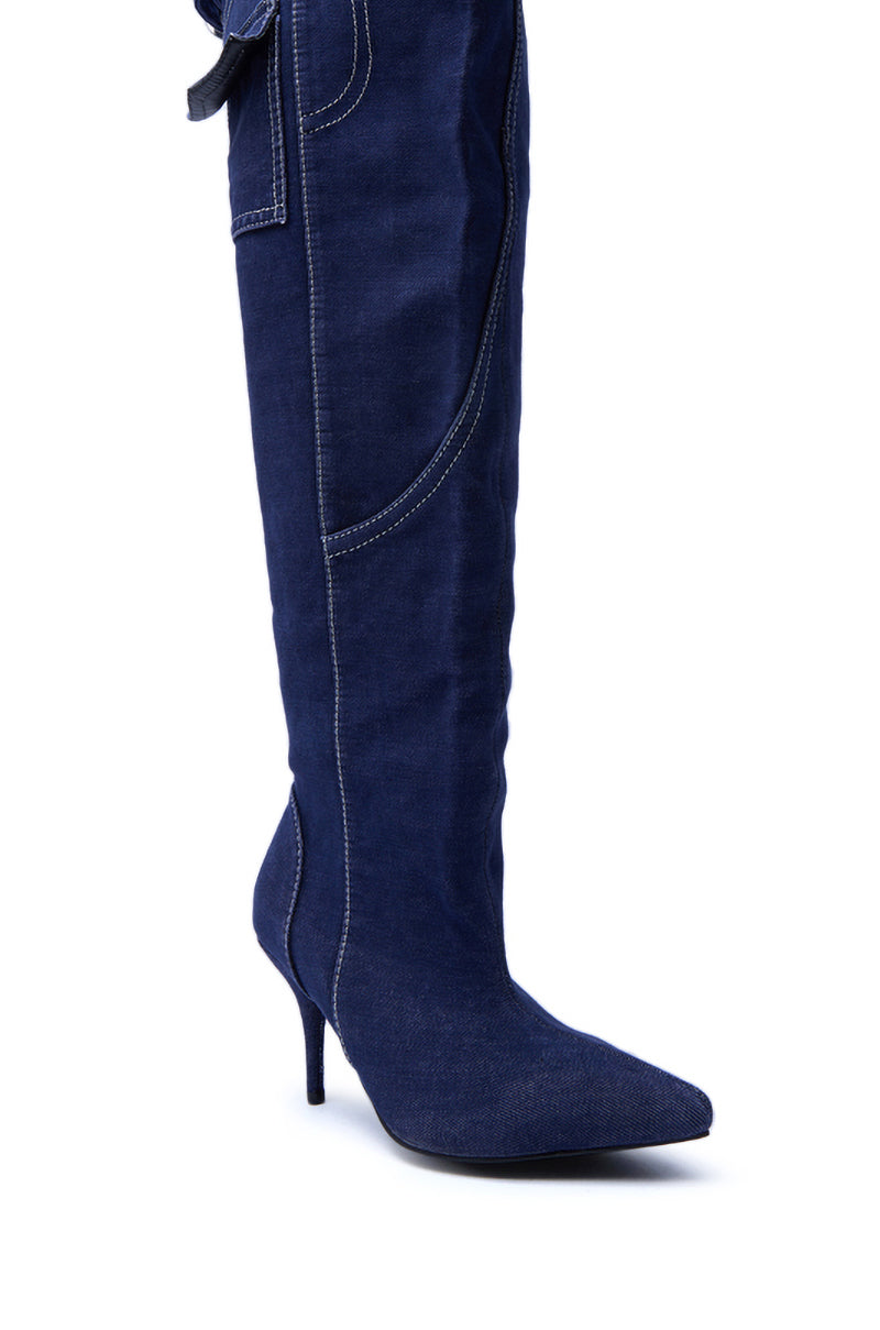 The AZALEA WANG DUSTAN DENIM THIGH STILETTO BOOT is a knee-high, pointed toe boot made from dark blue denim with white stitching and a sleek high heel.