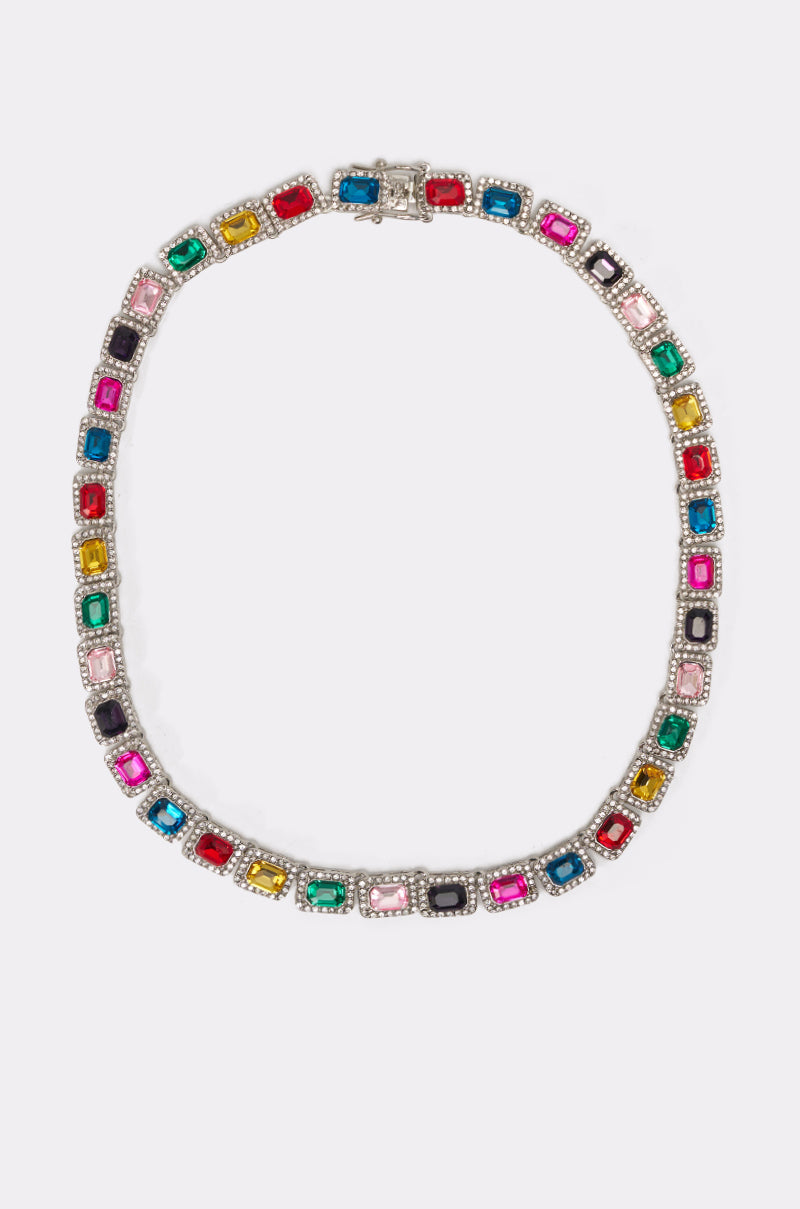 The HOW I MOVE NECKLACE is a silver tennis chain featuring square, multicolor gemstones in individual bezels, creating a vibrant continuous rainbow pattern for a bold statement look. 0