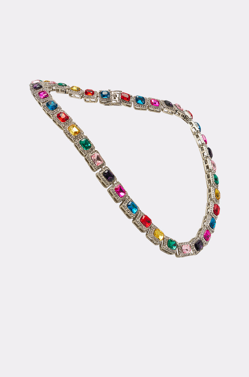 The HOW I MOVE NECKLACE is a silver tennis-chain featuring square and rectangular multicolored gemstones, evenly spaced along the chain and showcased on a plain white background. 2
