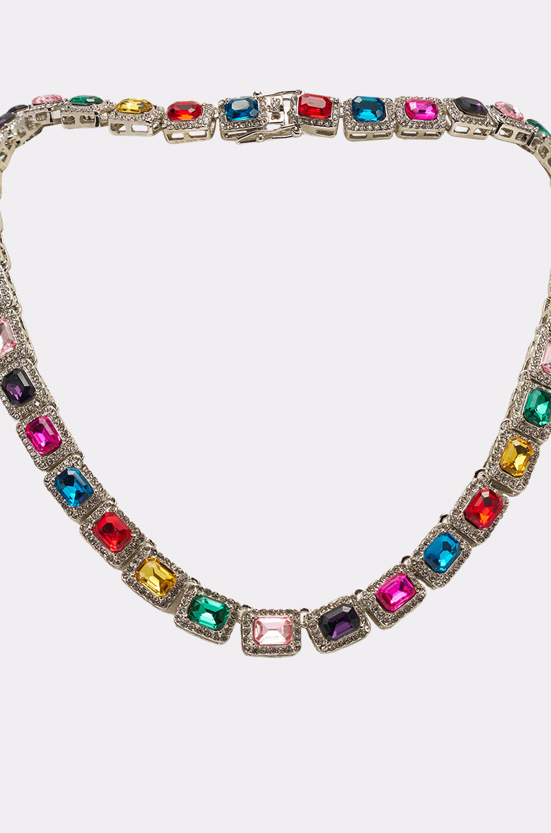The HOW I MOVE NECKLACE is a rainbow statement piece with rectangular multicolored gemstones set in silver, arranged symmetrically in a continuous tennis-chain design. 3