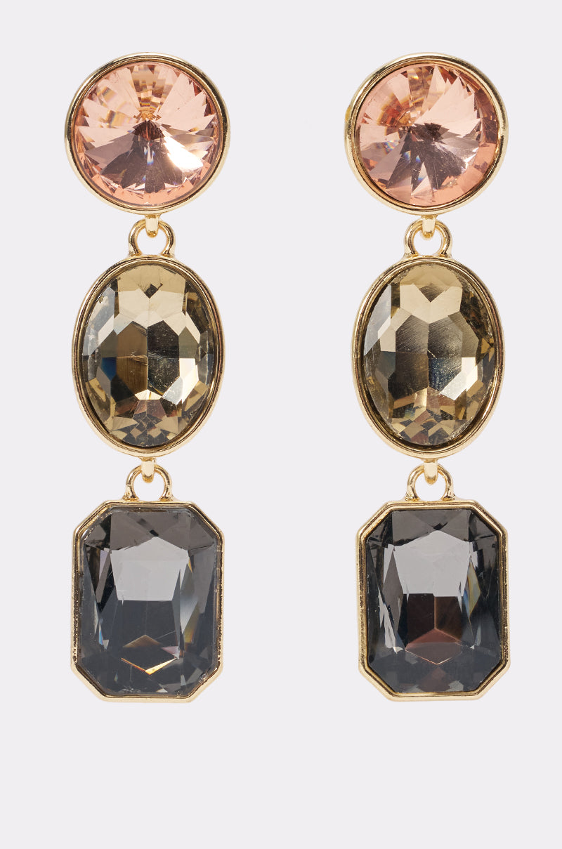 Introducing the SMOKY CRYSTAL DROP EARRINGS: A pair of crystal drop earrings with gold-tone hardware, featuring three vertically arranged faceted gemstones in pink, champagne, and smoky gray hues. Each earring showcases round, oval, and rectangular gemstone accents for a brilliant and eye-catching look.