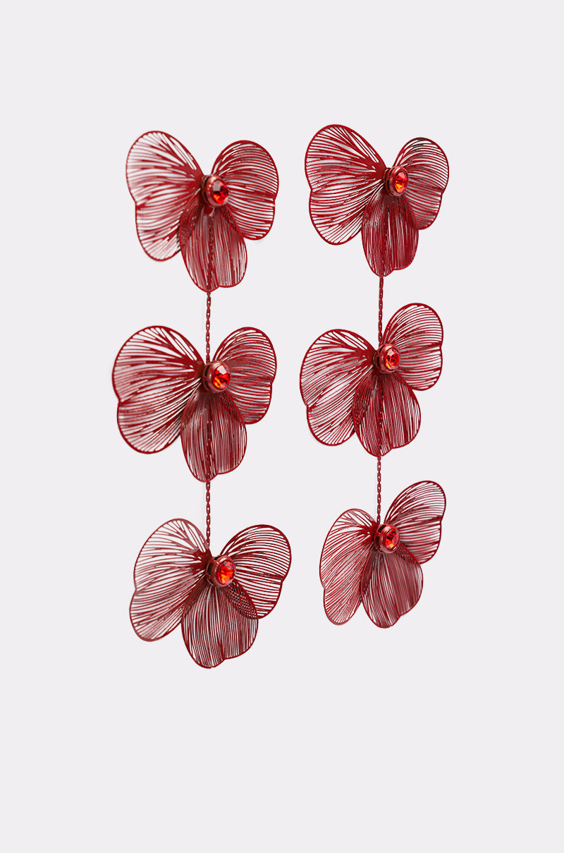 MY FUTURE EARRING: Red-tone earrings inspired by orchids, each with three layered floral shapes, detailed petals, and a central bead, displayed on a plain white background. 2