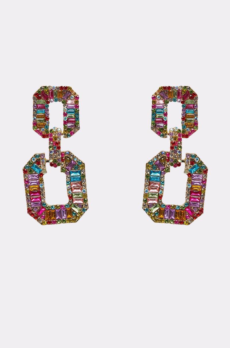 The TASTES LIKE CANDY EARRING is a pair of multicolor statement earrings with two linked octagonal shapes, encrusted with pink, blue, green, and yellow gemstones against a white background. 0