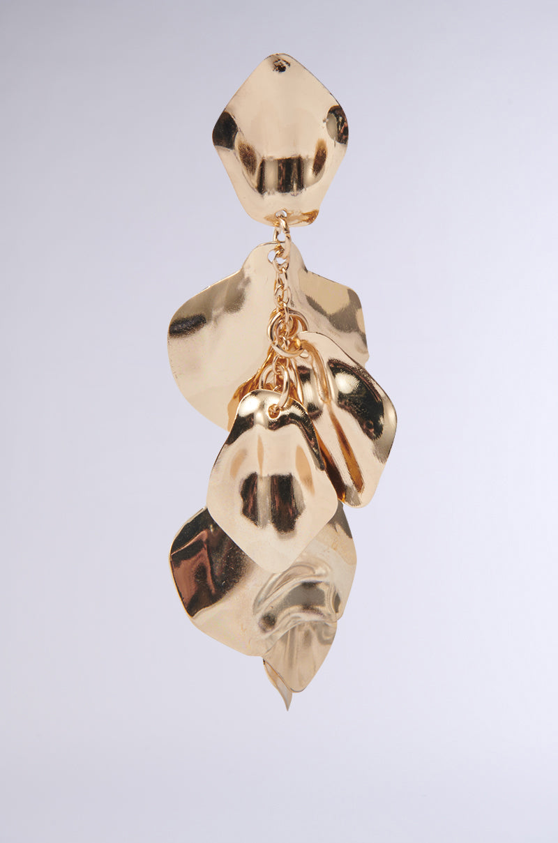 The NO THANKS EARRING features abstract textured shapes of overlapping, shiny faux gold plates dangling vertically with a smooth, reflective finish against a plain light background. 5