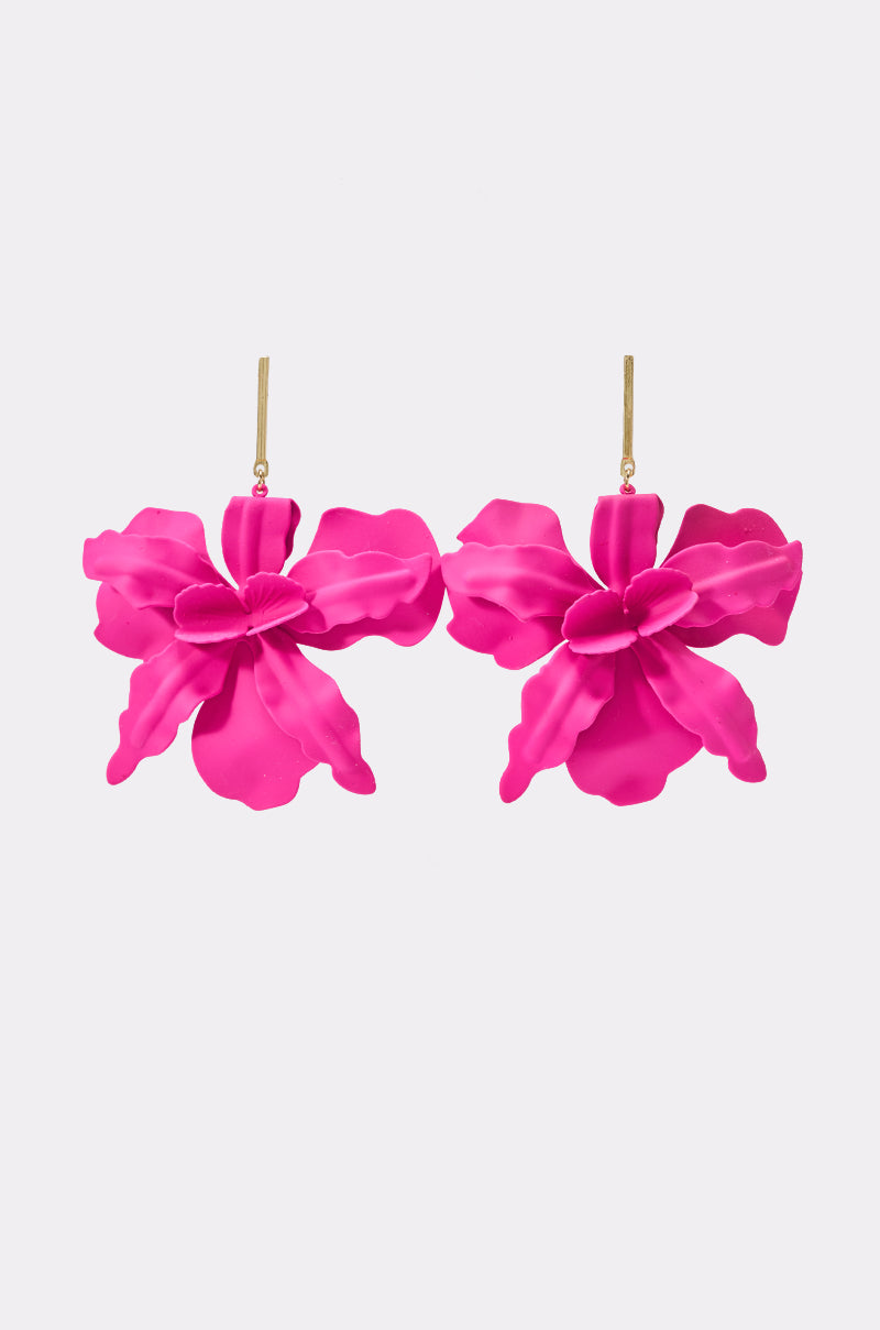 The FLOWER POWER EARRING features a vibrant pair of pink and gold floral earrings with gold hooks, each designed to resemble a blooming orchid—perfect as resortwear jewelry—displayed against a plain white background.
