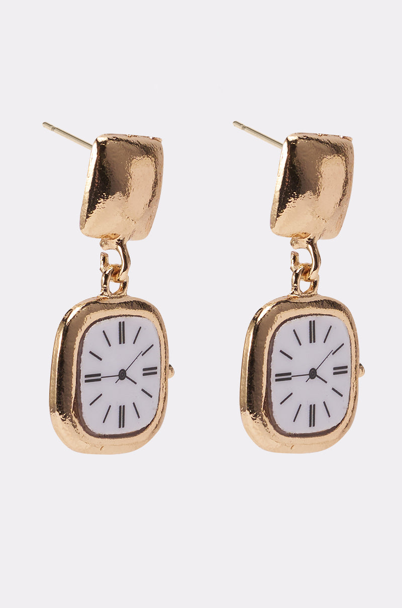 The OUTTA TIME EARRING features gold-tone dangle charms shaped like small clocks with white faces and black Roman numeral hour markers. 2