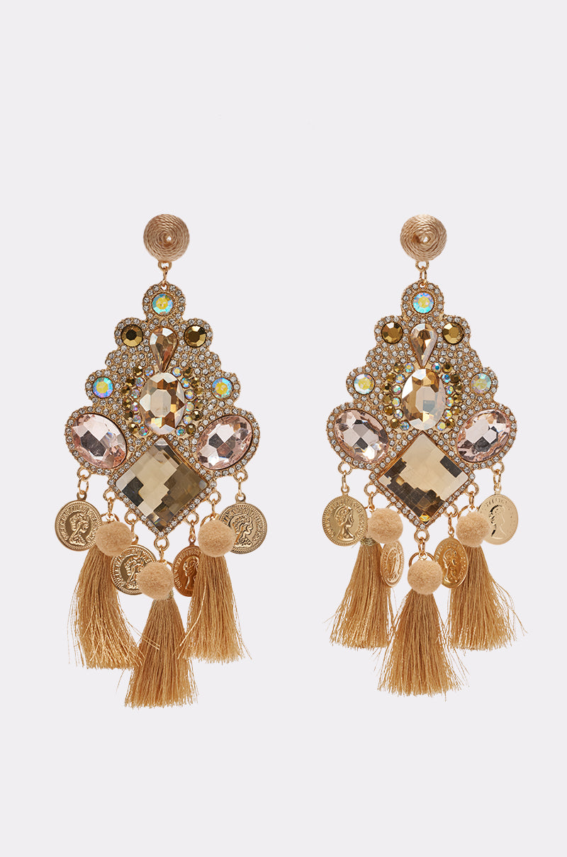 The BOHO VIBES TASSEL EARRING features gold chandelier-style earrings adorned with sparkling stones, small coin charms, and elegant gold tassels at the bottom—an ideal fusion of festival jewelry and boho-chic style—all beautifully showcased against a plain white background.