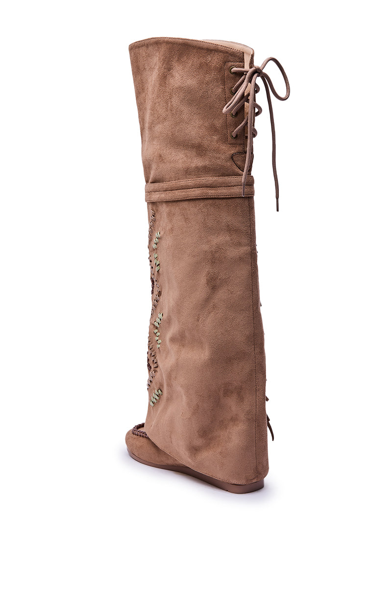 The AZALEA WANG EDMUND BROWN FLAT WESTERN BOOT is a tan faux suede knee-high style with a flat sole, lace-up top detail, and decorative side stitching, shown against a white background.