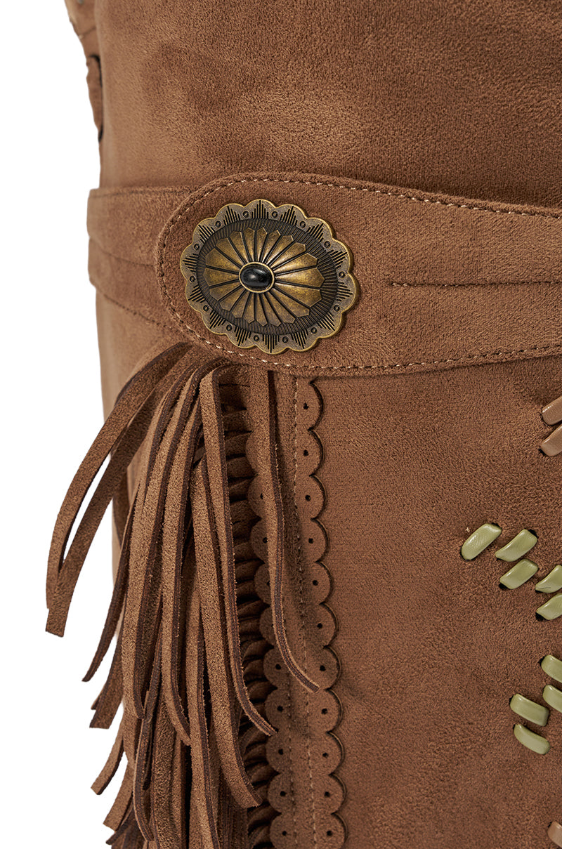 Close-up of the AZALEA WANG EDMUND BROWN FLAT WESTERN BOOT featuring brown faux suede, fringe accents, brass concho detail, scalloped edges, and metal studs. 7