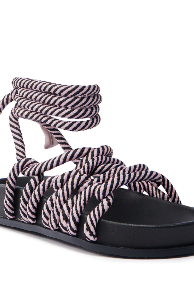 The AKIRA EINER PURPLE ROPE SANDAL features a black sole and woven black and white striped rope straps. Its crisscross design wraps around the foot and ankle, offering a distinct, stylish look for summer.