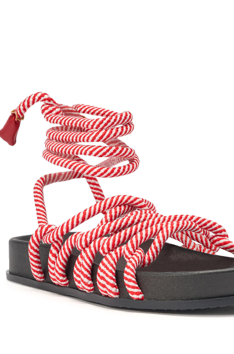 The AZALEA WANG EINER RED ROPE FLATFORM SANDAL features a thick black sole and red-and-white striped rope straps that crisscross over the foot and wrap around the ankle, making it perfect summer footwear for bold style. 7