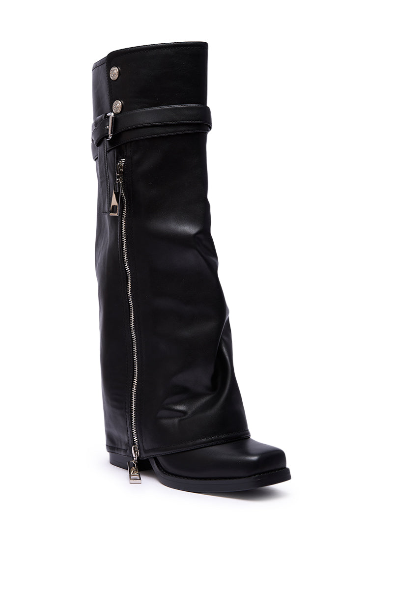The AZALEA WANG EIRA CHUNKY BOOTIE WITH SQUARE TOE is a single black leather knee-high boot featuring a slouched shaft, side zipper, decorative strap with metal buttons at the top, and a bold square toe.