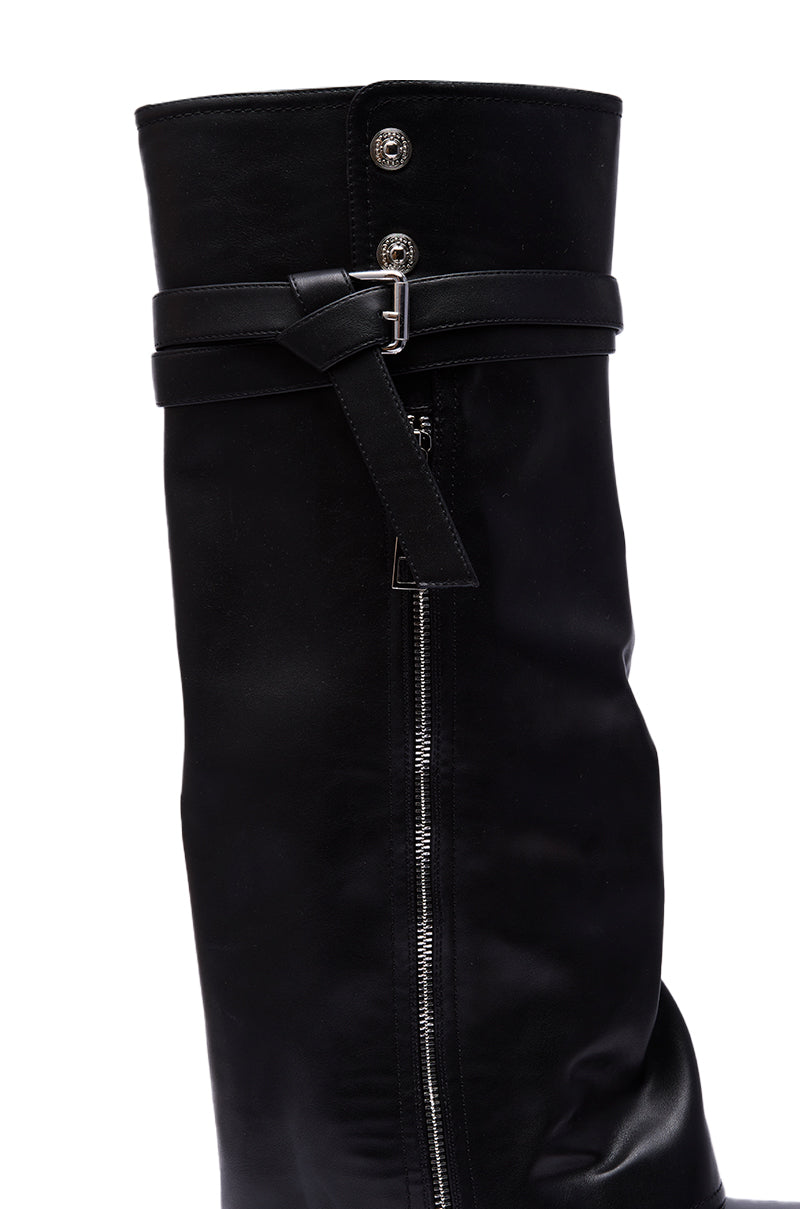 Close-up of the AZALEA WANG EIRA CHUNKY BOOTIE WITH SQUARE TOE, a knee-high black leather boot with a square toe, side zipper, decorative strap with metal buckle, and two metallic buttons at the top.