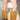 A person wearing black pinstripe shorts and AZALEA WANG EKKEN RED FOX FUR STILETTO BOOTS with tall, furry orange and gray leg warmers stands on a sunlit asphalt surface.