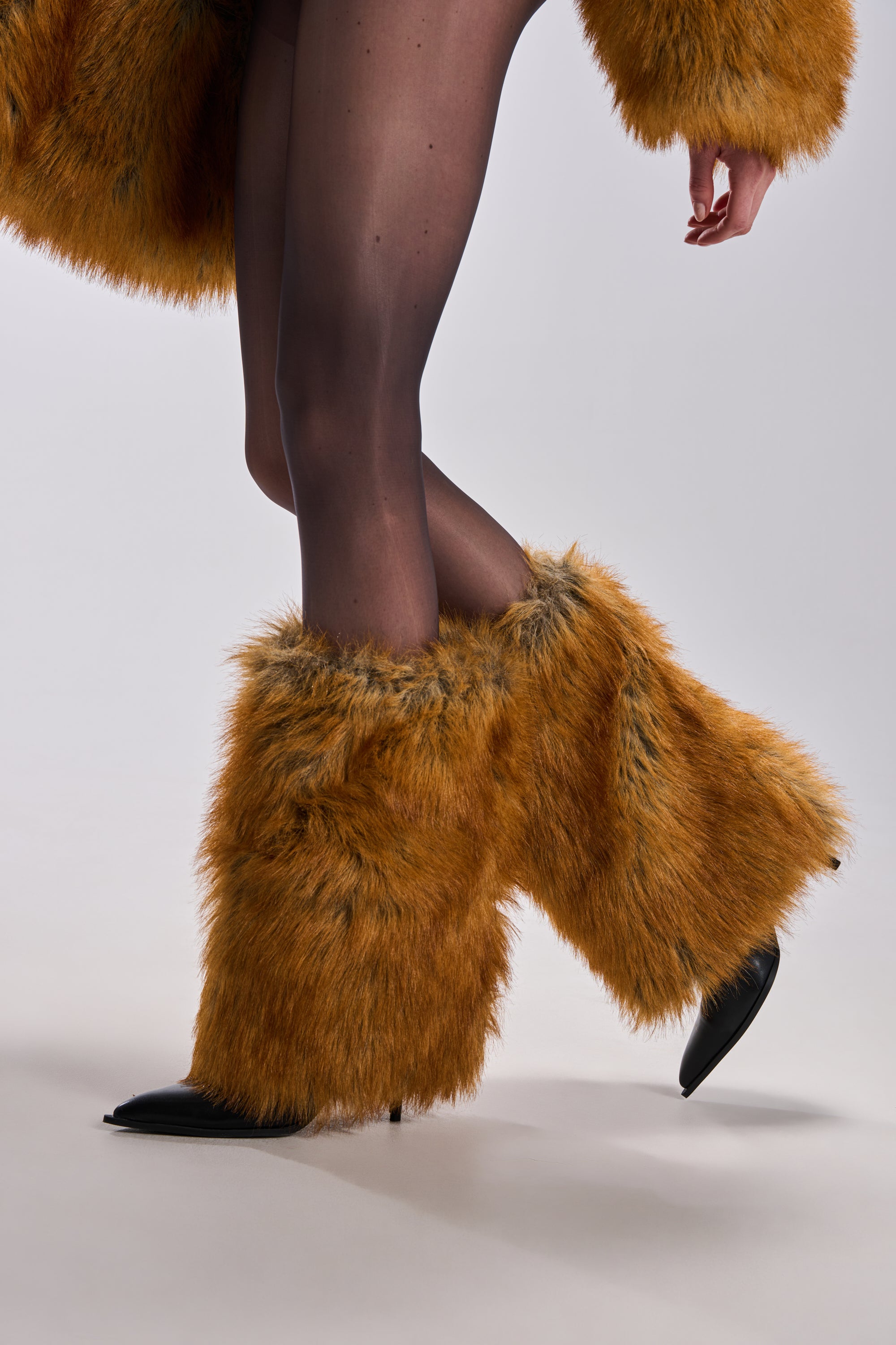 A person wears black sheer tights and the AZALEA WANG EKKEN RED FOX FUR STILETTO BOOT with large orange faux fur, plus part of a matching fur coat is visible, all against a plain white background.
