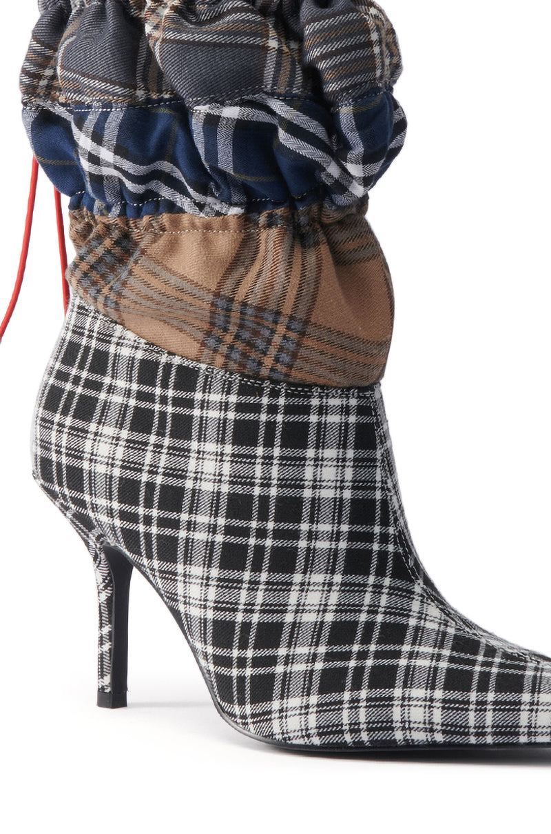 The AZALEA WANG ELADIES MULTI BOXER BOOTIE features a high stiletto heel, black-and-white plaid with pointed toe, and layered ruched cuffs in blue, brown, and black heritage tartans above the ankle for a bold statement look.