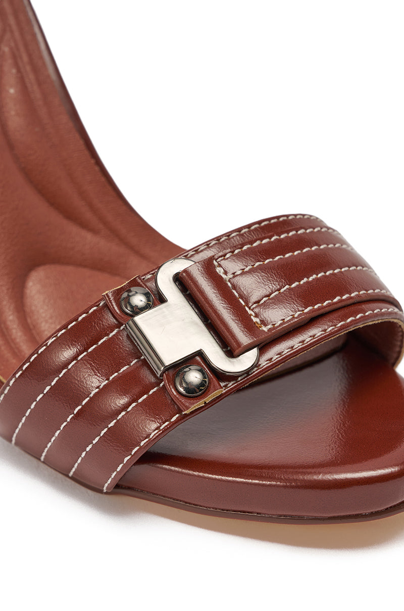 Close-up of the AKIRA GOLD ELEGY BROWN CROC BUCKLE HARDWARE STILETTO SANDAL, featuring brown faux leather with a silver buckle on the toe strap, white stitching, and a comfort cushion insole for added support. 6