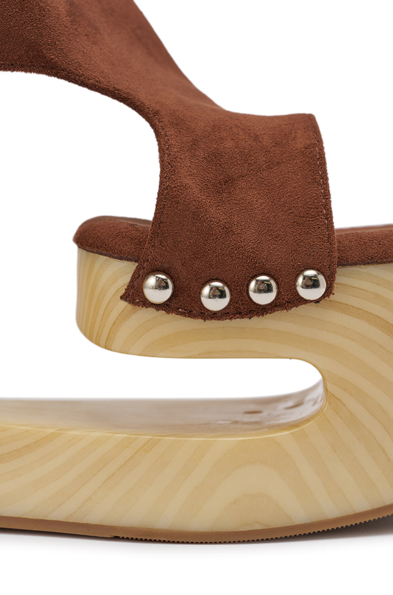 Close-up of the AZALEA WANG ELGEDI TAN PLATFORM SANDAL, featuring a curved light wooden wedge heel, silver rivets, and a brown suede upper strap. 9