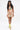 A woman with long dark hair in high pigtailed ponytails wears a colorful FLOUNCE CORSET MINI DRESS featuring an abstract print, mixed fabric, a pleated hem, and yellow lace-up heels. She stands against a plain white backdrop.