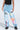 Wearing FIRST CLASS TICKET GRAPHIC CARGO RELAXED LEG JEANS in light blue with colorful graffiti graphics like "TAKE ME TO PARIS" and "TOKYO ARTS PLAN," styled with a black top and black platform shoes.