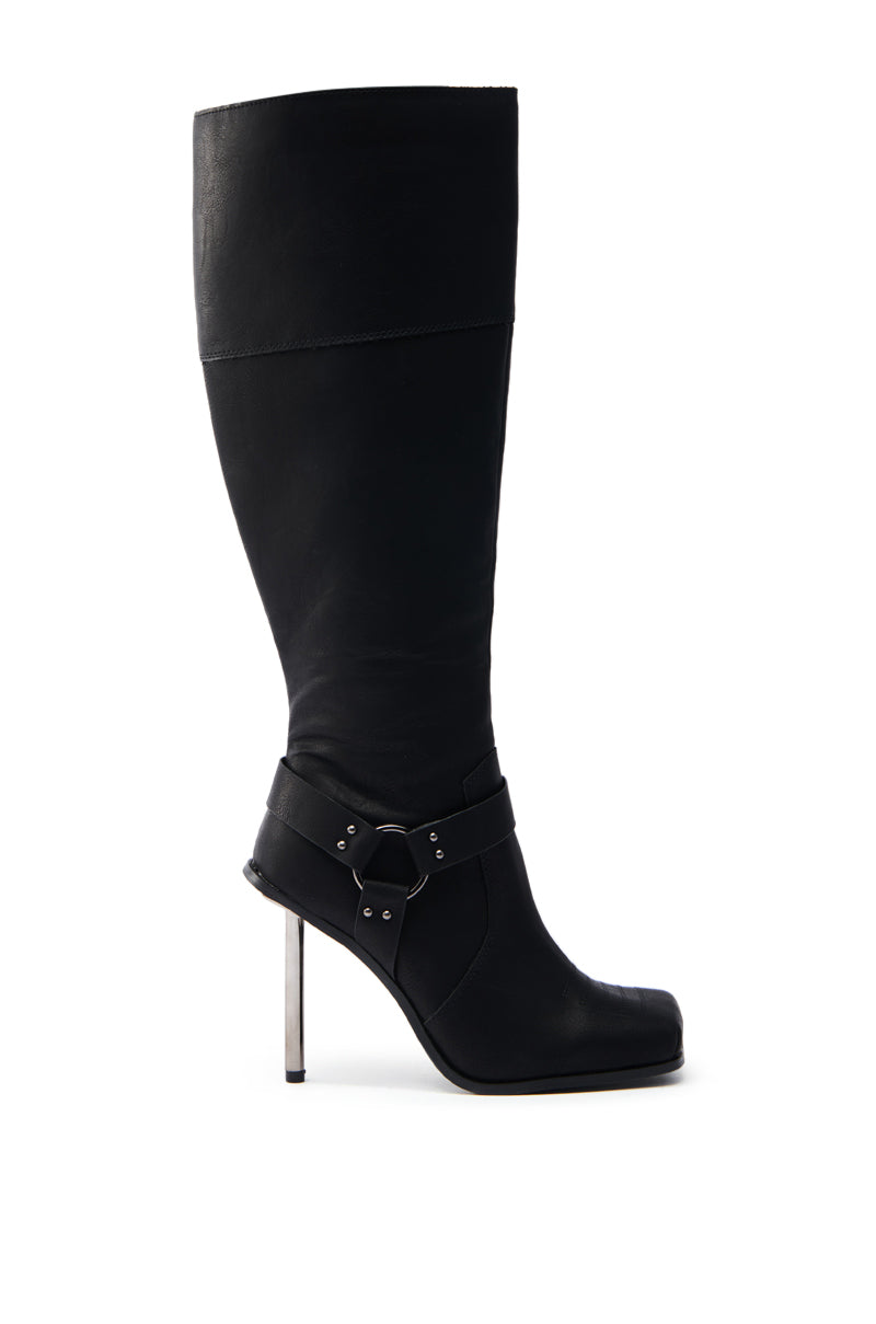 The ELLERY BLACK STILETTO BOOT features a sleek faux leather design with a pointed toe, knee-high shaft, ankle strap with buckle, and a thin metal stiletto heel for elegance.