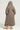 Wearing the BEAR HUG REVERSIBLE FLEECE TRENCH, a person stands with their back to the camera. The long, hooded coat features an oversized silhouette in brown sherpa knit that pairs perfectly with tan ankle boots, against a plain and neutral background.