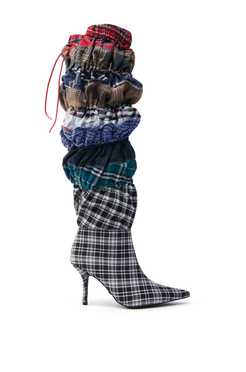 The AZALEA WANG ELODIE MULTI BOXER BOOT features a tall stiletto heel, pointed toe, and layers of colorful textured plaid fabrics that create a scrunched, voluminous look with patterns in red, blue, green, and black.