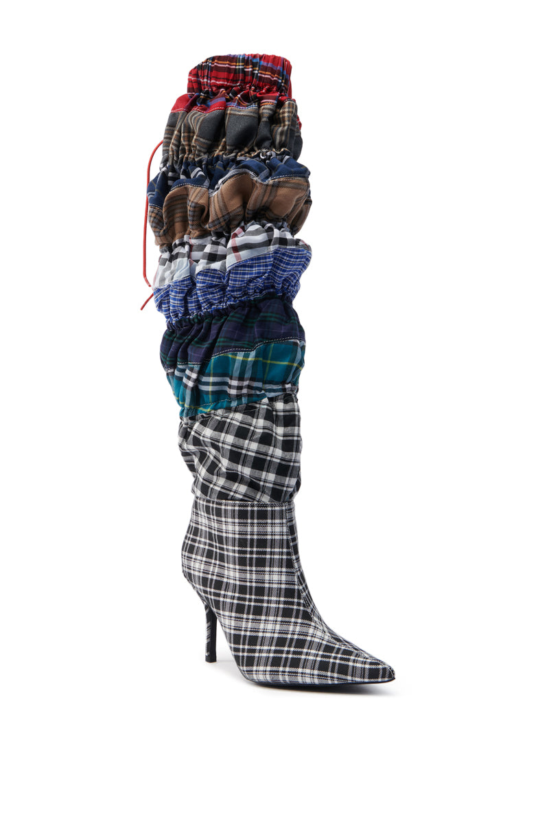 The AZALEA WANG ELODIE MULTI BOXER BOOT is a knee-high fashion-forward shoe with a pointed toe and sleek stiletto heel. It features layered plaid patterns in red, blue, green, and brown for a unique and artistic design.