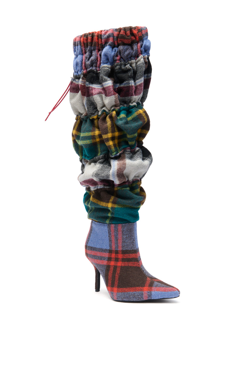 The AZALEA WANG ELODIE PLAID MULTI FLANNEL STILETTO BOOT features a pointed toe, knee-high silhouette, and colorful scrunched flannel in red, blue, green, yellow, and white plaid patterns.
