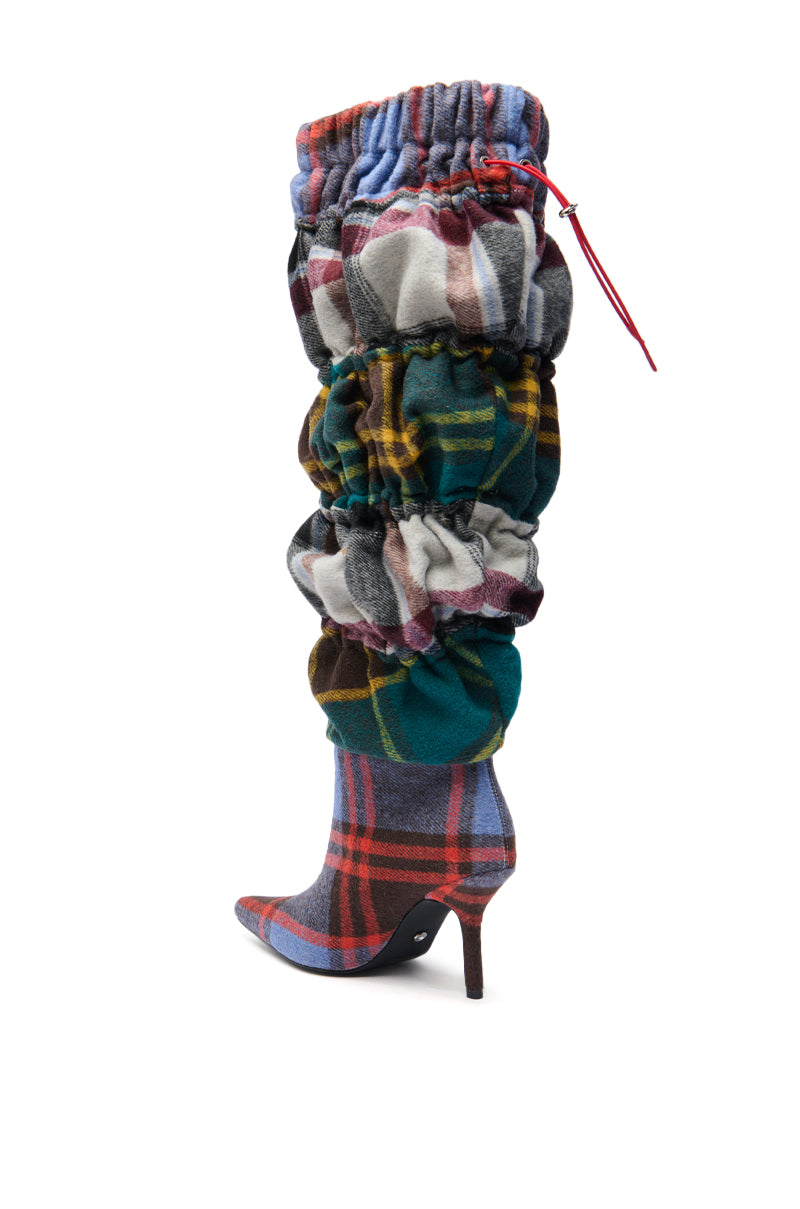 The AZALEA WANG ELODIE Plaid Multi Flannel Stiletto Boot is a knee-high, slouchy plaid boot with a pointed toe and red drawstring, crafted from gathered flannel in vibrant red, green, blue, and yellow tones.