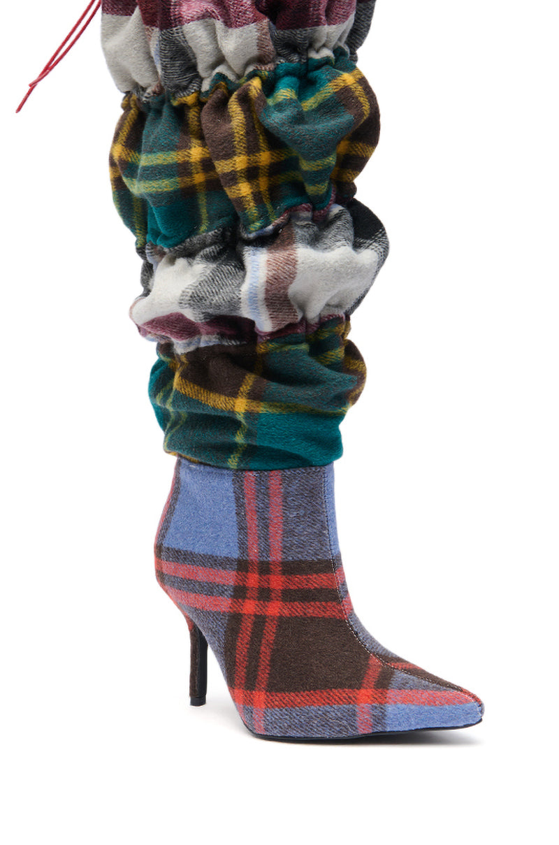 The AZALEA WANG ELODIE PLAID MULTI FLANNEL STILETTO BOOT features a vibrant blue, red, brown, and yellow plaid pattern with a pointed toe and matches ruched pants for a striking, coordinated look.
