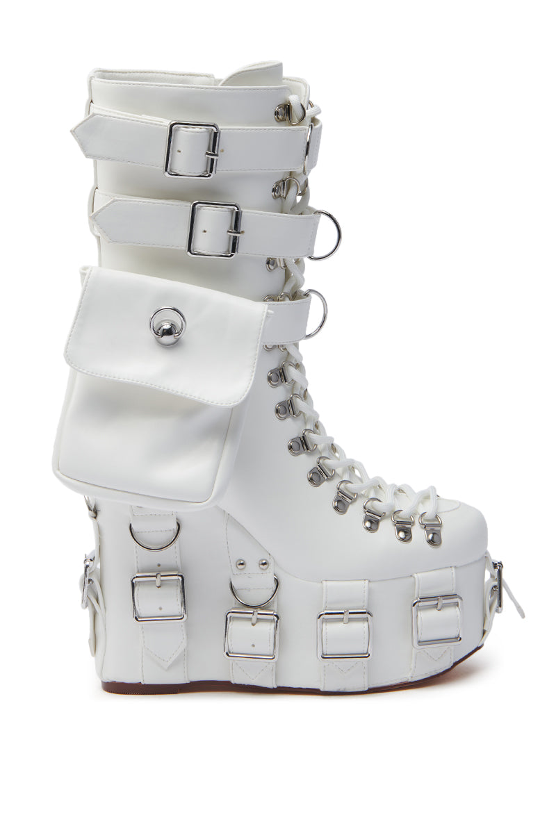 The AZALEA WANG ELOWYN white edgy wedge boot is crafted from faux leather, featuring decorative buckles, laces, and a side pouch. It boasts a chunky sole with metallic details and a side ring, enhancing its striking appeal.