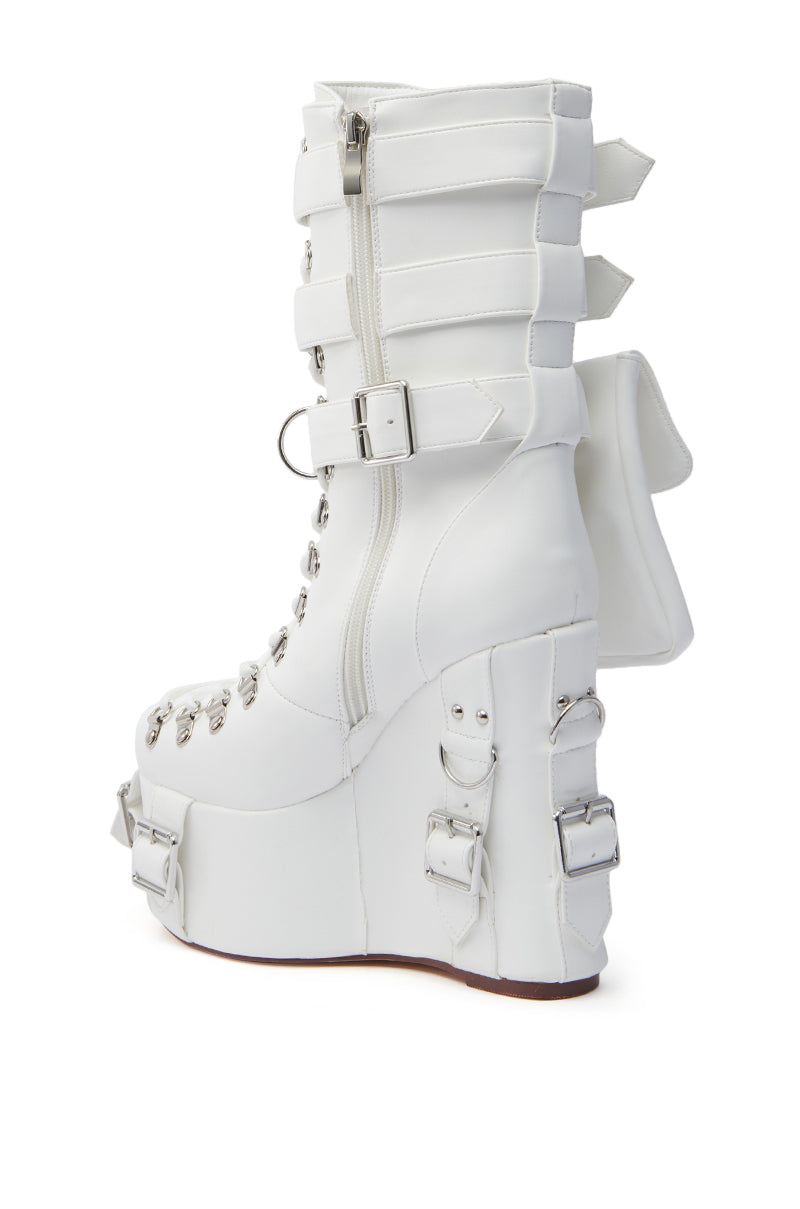Explore the AZALEA WANG ELOWYN WHITE EDGY WEDGE BOOT, featuring sleek faux leather, a high wedge heel, multiple decorative buckles, metal eyelets, and a large striking bow on the back.