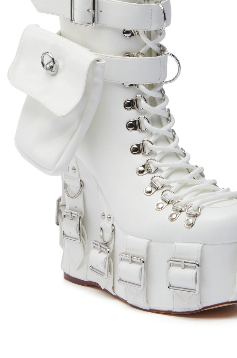 The AZALEA WANG ELOWYN WHITE EDGY WEDGE BOOT is crafted from faux leather with laces, multiple decorative silver buckles, a side pouch, and a high chunky heel with a bold, futuristic design.
