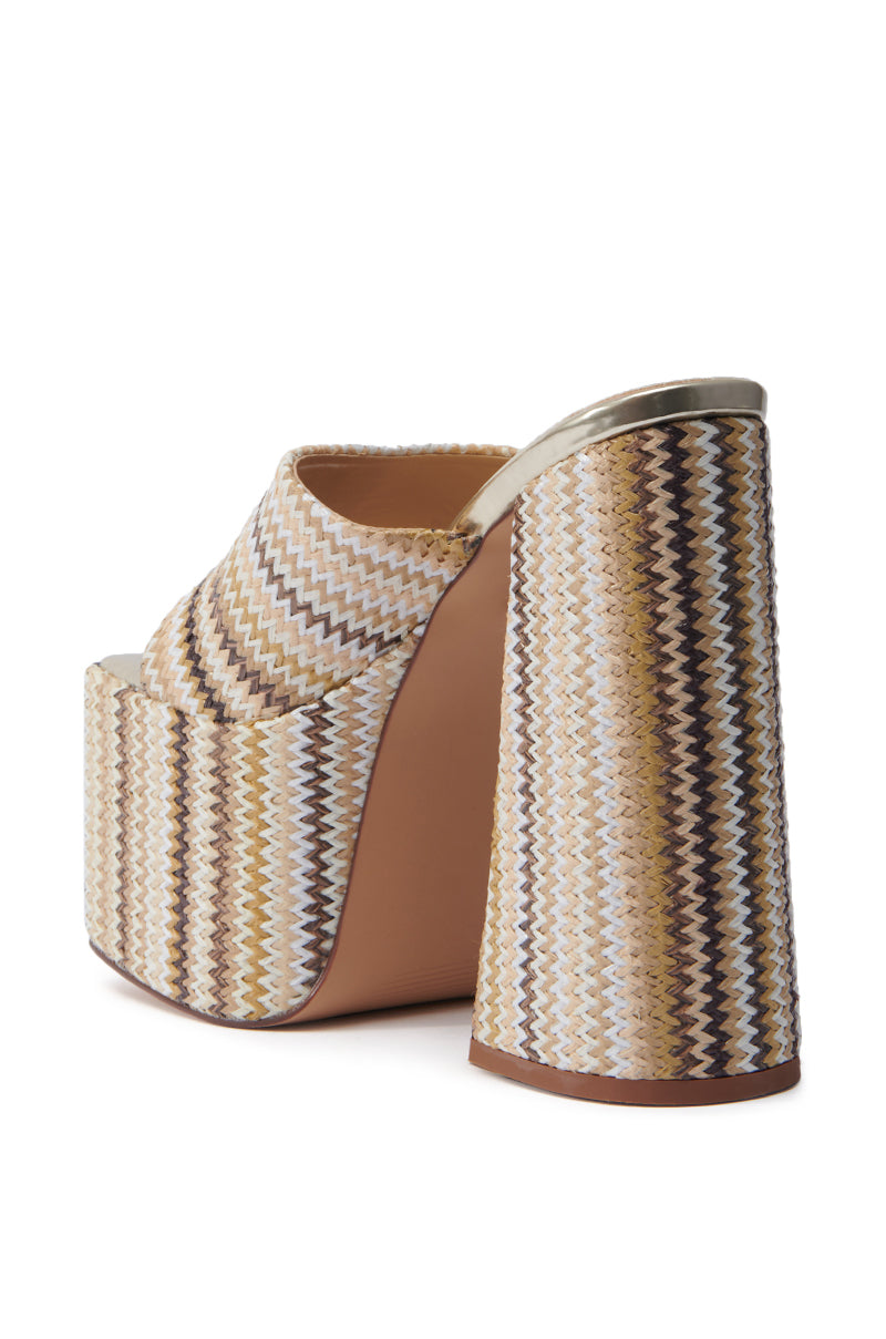 The AZALEA WANG EMBERS BROWN CHUNKY PLATFORM SANDAL features a high-heeled design with an open square toe and a raffia upper. It's adorned with a zigzag pattern in beige, brown, and white, complemented by a thick heel and gold trim on the top edge.