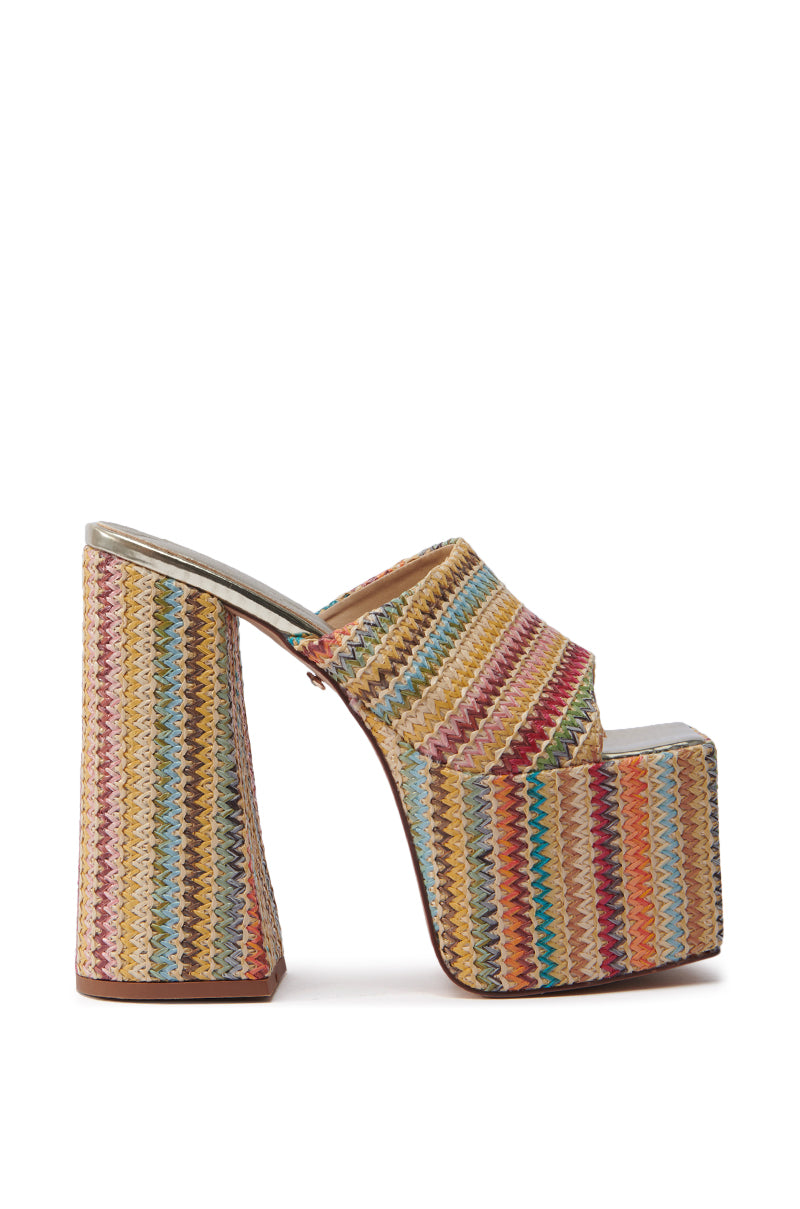The AZALEA WANG EMBERS MULTI CHUNKY PLATFORM SANDAL is a vibrant open-toe design featuring a chunky heel, crafted from raffia upper, and adorned with a multicolored zigzag pattern in pink, blue, beige, and green.