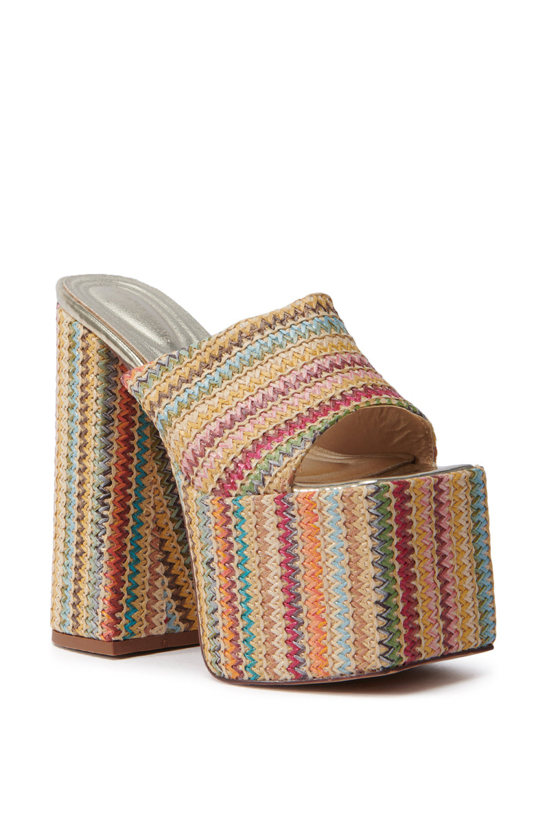 The AZALEA WANG EMBERS MULTI CHUNKY PLATFORM SANDAL features a chic raffia upper in a multicolored woven pattern. It has a chunky heel, open toe design, and vibrant zigzag stripes for a playful, stylish look.