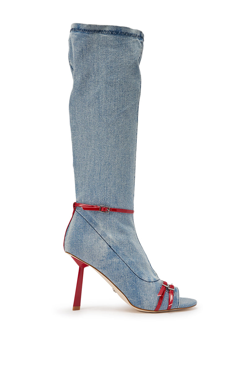 The AZALEA WANG EMIRA DENIM STILETTO OPEN TOE BOOT is a knee-high denim boot with an open toe, bold red stiletto heel, and striking red straps across the foot and ankle. 3