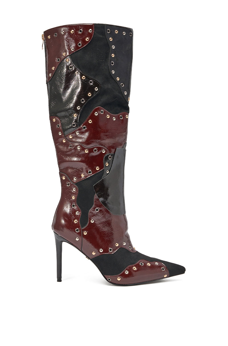 The AKIRA GOLD ENYAE Mahogany Multi Patchwork Stiletto Boot features a tall, pointed-toe silhouette, black, dark red, and shiny burgundy faux leather panels, and small metallic studs accenting the seams. 2