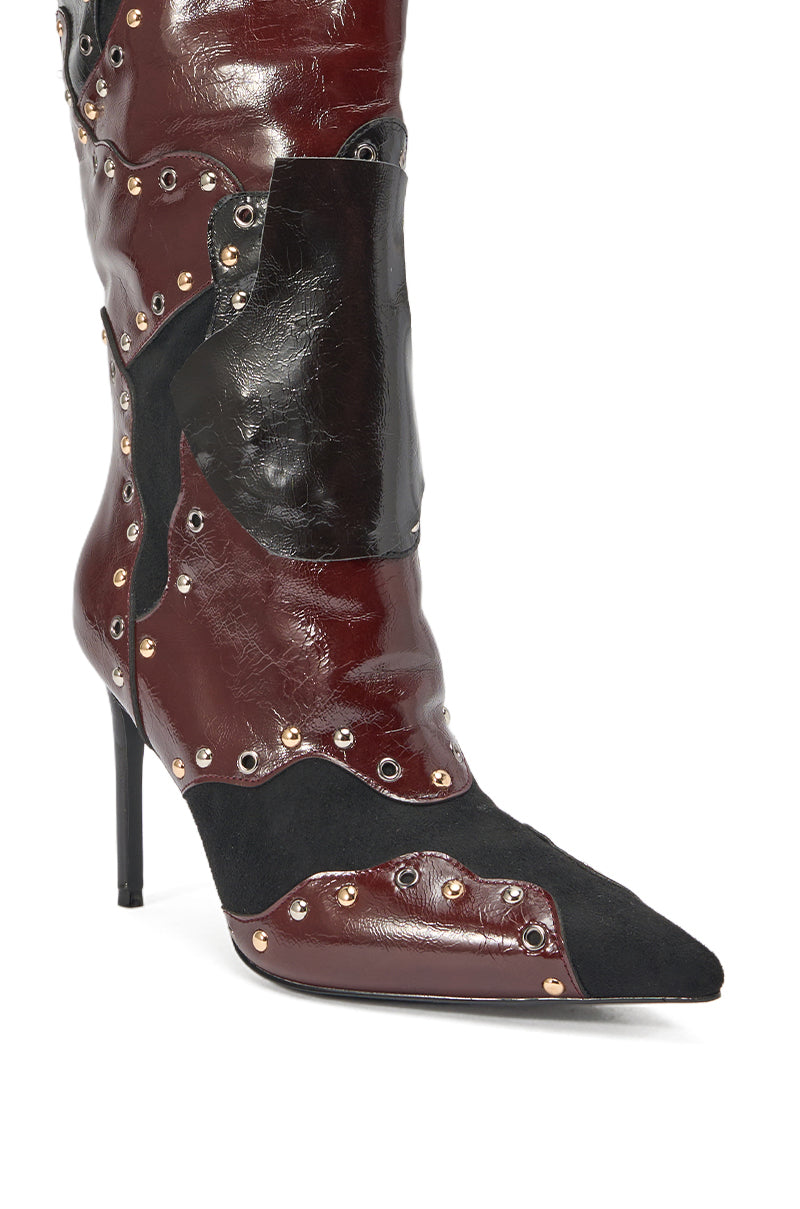 The AKIRA GOLD ENYAE MAHOGANY MULTI PATCHWORK STILETTO BOOT features a pointed toe, stiletto heel, dark red and black faux leather with suede, plus metal studs and grommet details in a bold patchwork design. 5
