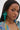 A woman with long straight hair wears TOTEALLY EARRING—oversized floral earrings with gemstone centers—and a multicolored striped top, looking at the camera with a neutral expression against a plain background.