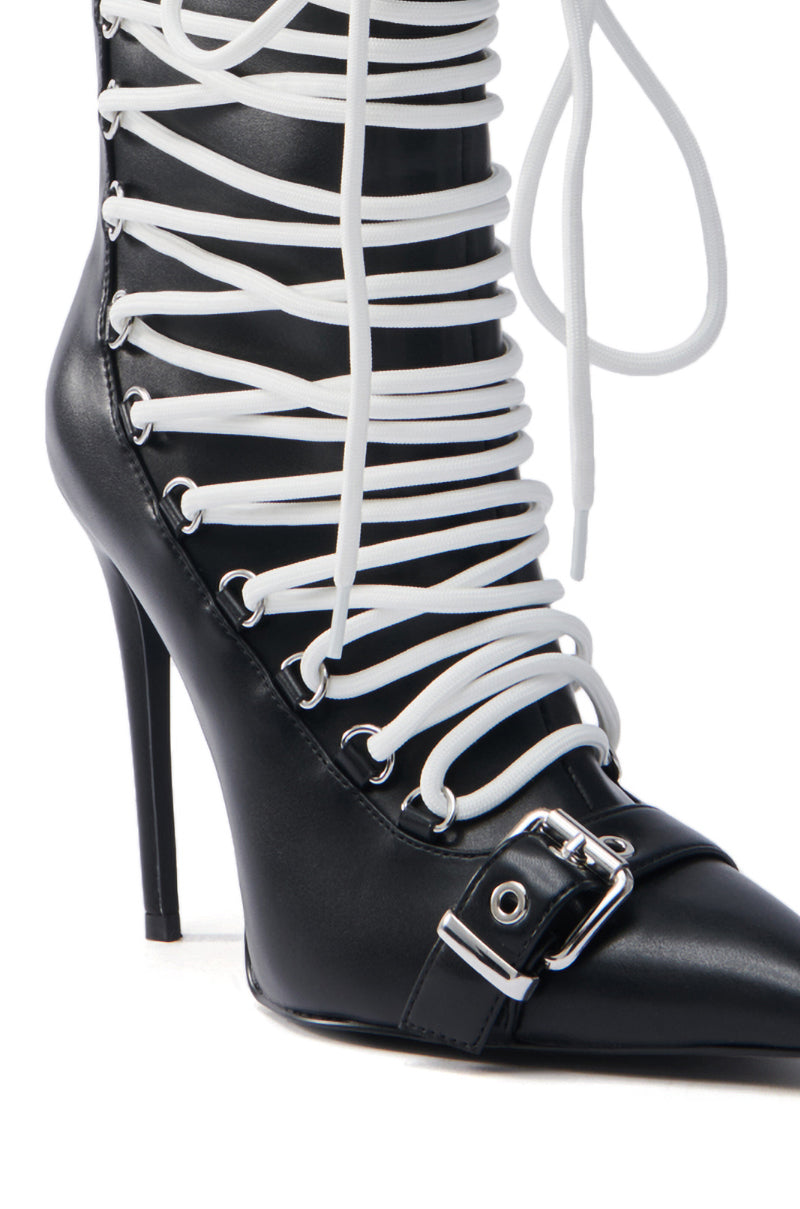 The AZALEA WANG ERYX Black Lace Up Stiletto Bootie features white crisscross laces and a metal buckle detail on the lower front. It has a pointed toe, tall slender stiletto heel, and is crafted from sleek faux leather.