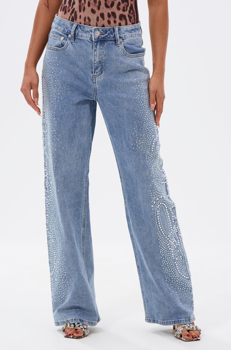 Someone models the DREAMING OF YOU WIDE LEG DENIM in light blue with a leopard print top and open-toe heels, standing against a plain white background. 0