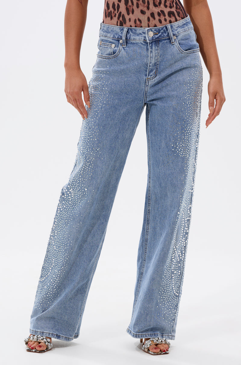A person wearing the DREAMING OF YOU WIDE LEG DENIM jeans styled with a leopard print top and open-toe sandals, standing against a plain white background. 1