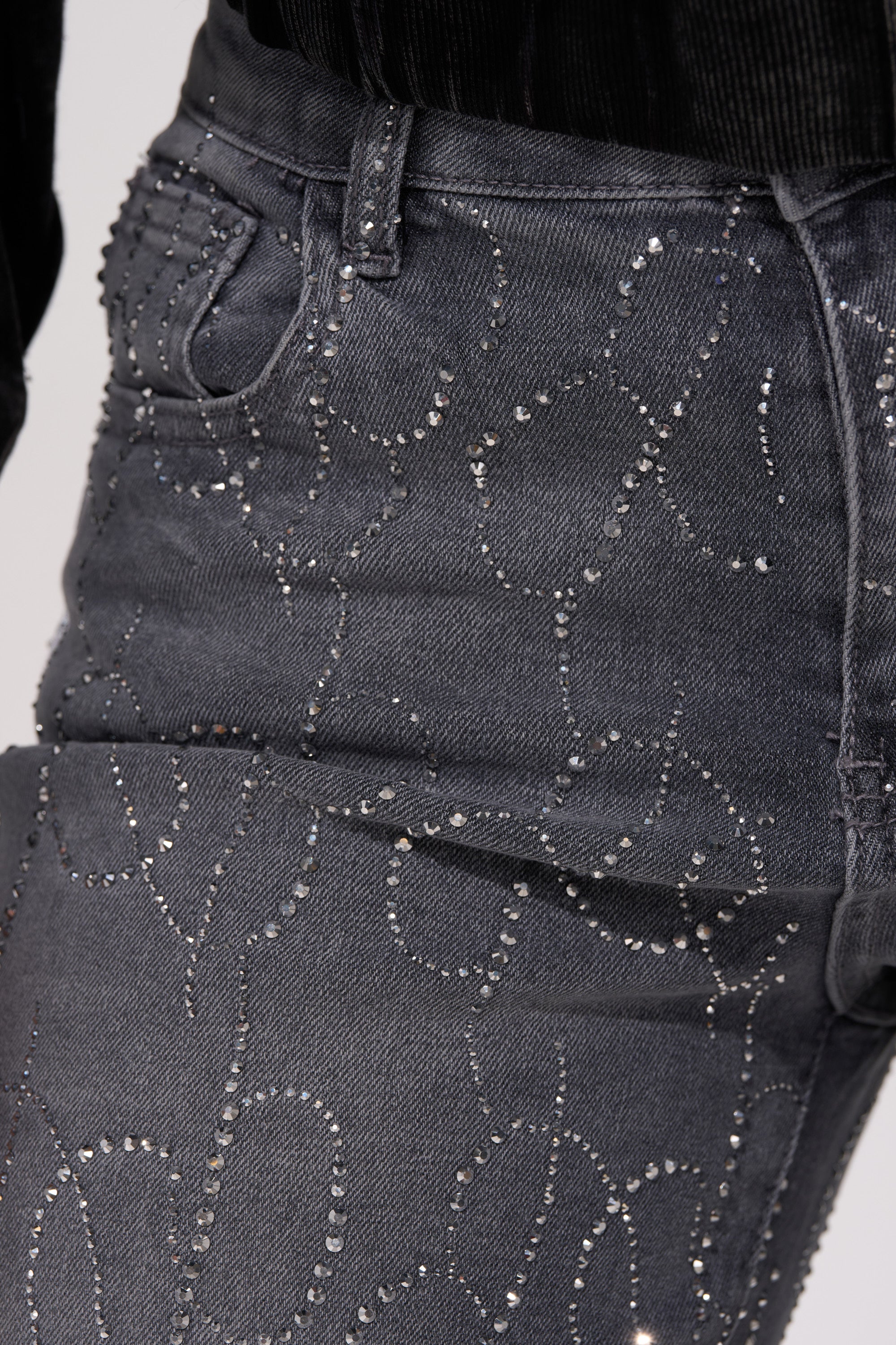Close-up of PERFECT LIKE ME EMBELLISHED DENIM: gray high-rise straight-leg jeans with swirling rhinestone patterns, paired with a black ribbed top.