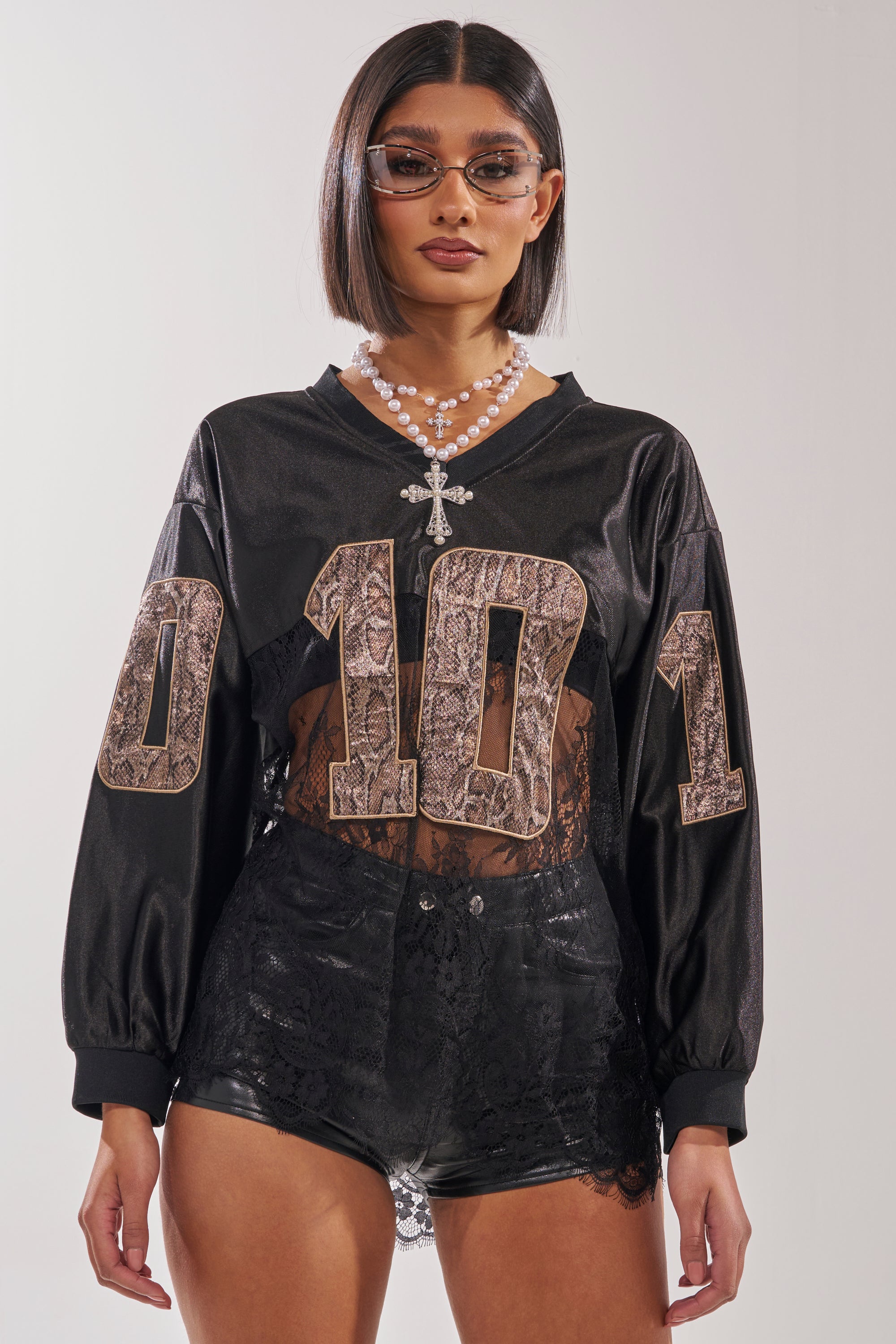 A woman in an oversized ROCKY LACE JERSEY top, perfect for a streetwear-ready look. 3